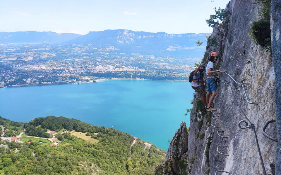 Via ferrata avec vue plongeante sur un lac de montagne.